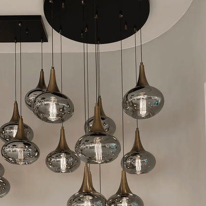 Bronze conical pendant lighting with transparent glass globes and exposed bulbs.