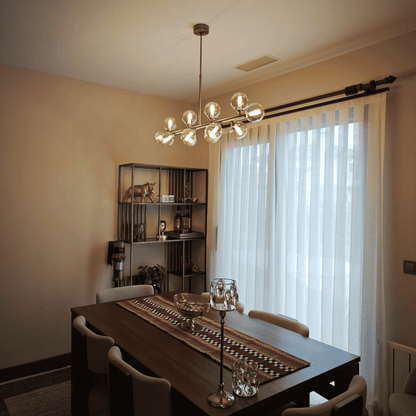 Clear Globe Glass Chandeliers Over Dining Table