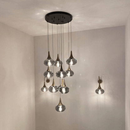 Multi-light pendant installation with glass globes and brass accents in a modern staircase.