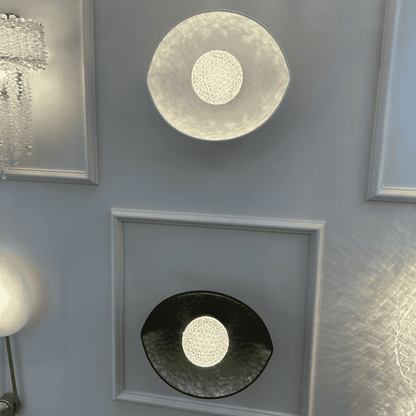 Display of black and white plexiglass LED sconces showing contrast in finishes and balanced ambient light.