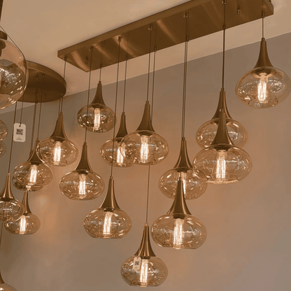 : Pendant lights with amber glass globes and bronze fittings aligned on a rectangular ceiling plate.