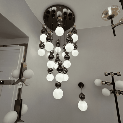 Cascading modern pendant lighting fixture with frosted and reflective glass globes for stylish interiors.