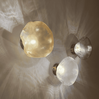 Three natural stone glass wall sconces in varied finishes project layered ambient light patterns.