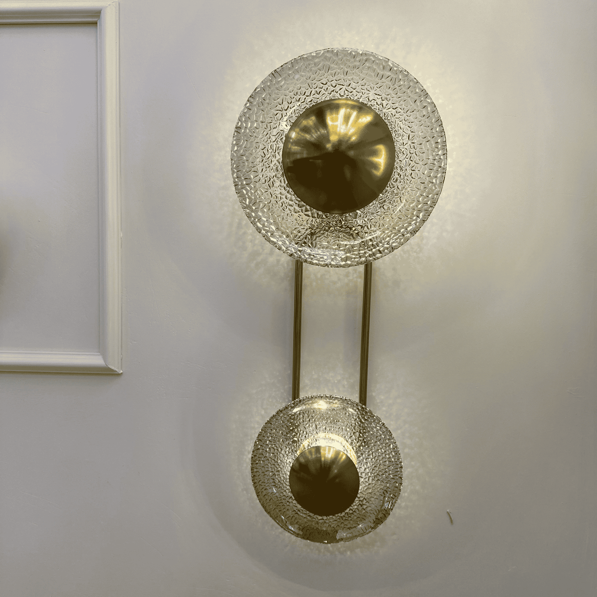 Double glass and brass wall sconce for living room with halo glow, 60 cm height.